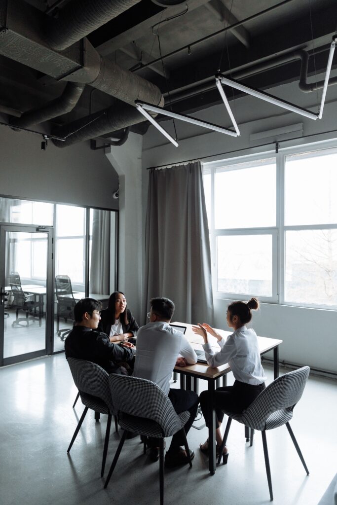 A group of professionals engaged in a business meeting inside a contemporary office setting.